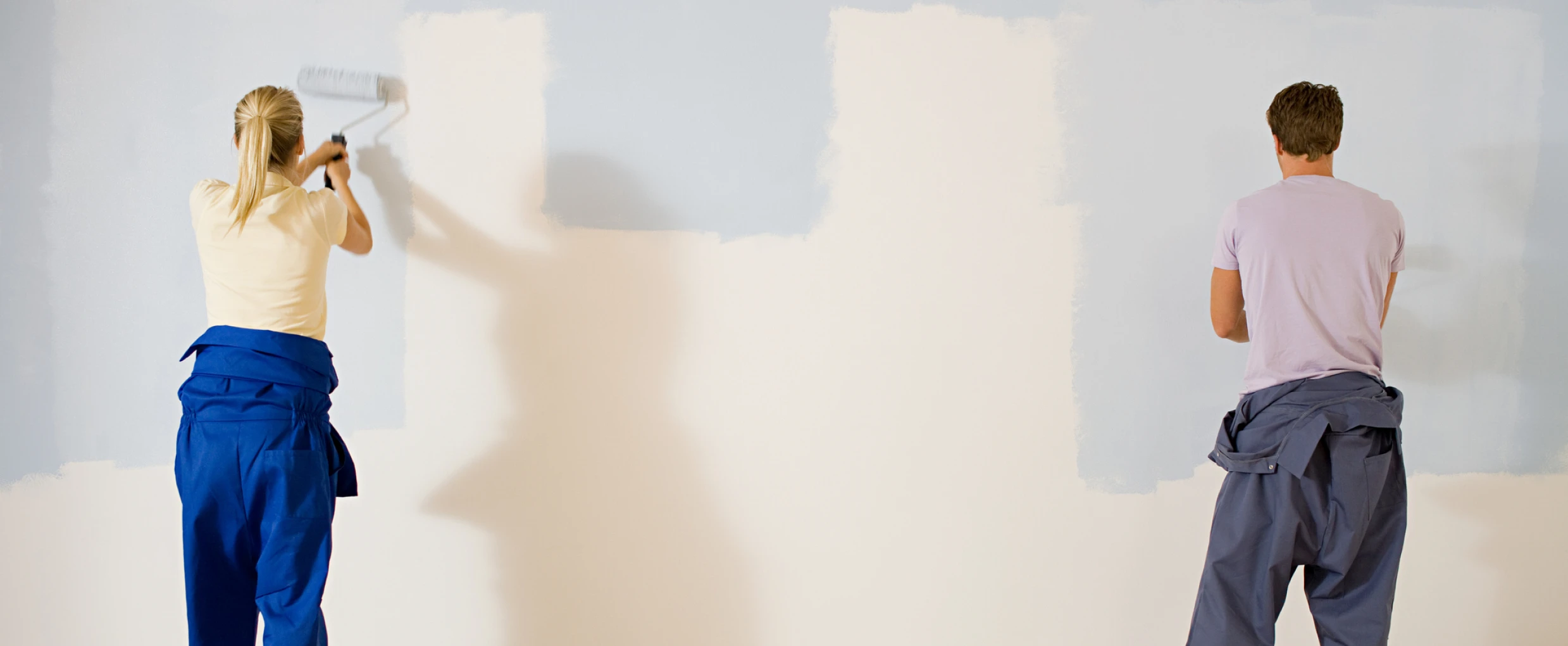 Man and woman painting a wall