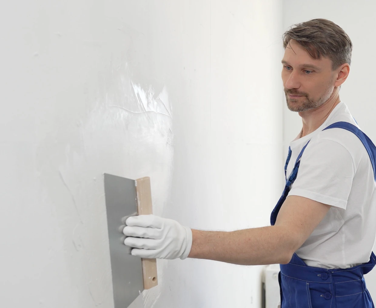 Man plastering a wall with trowel